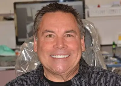 Patient smiling with straight, even, white teeth after receiving treatment at Signature Dentistry of Arvada