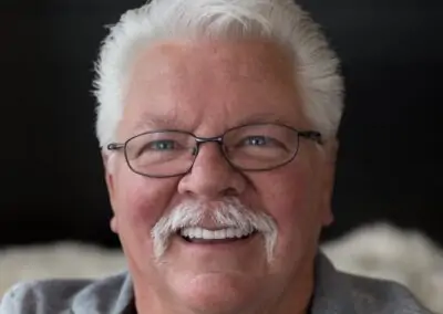 A patient smiling with straight, even, white teeth after receiving treatment at Signature Dentistry of Arvada