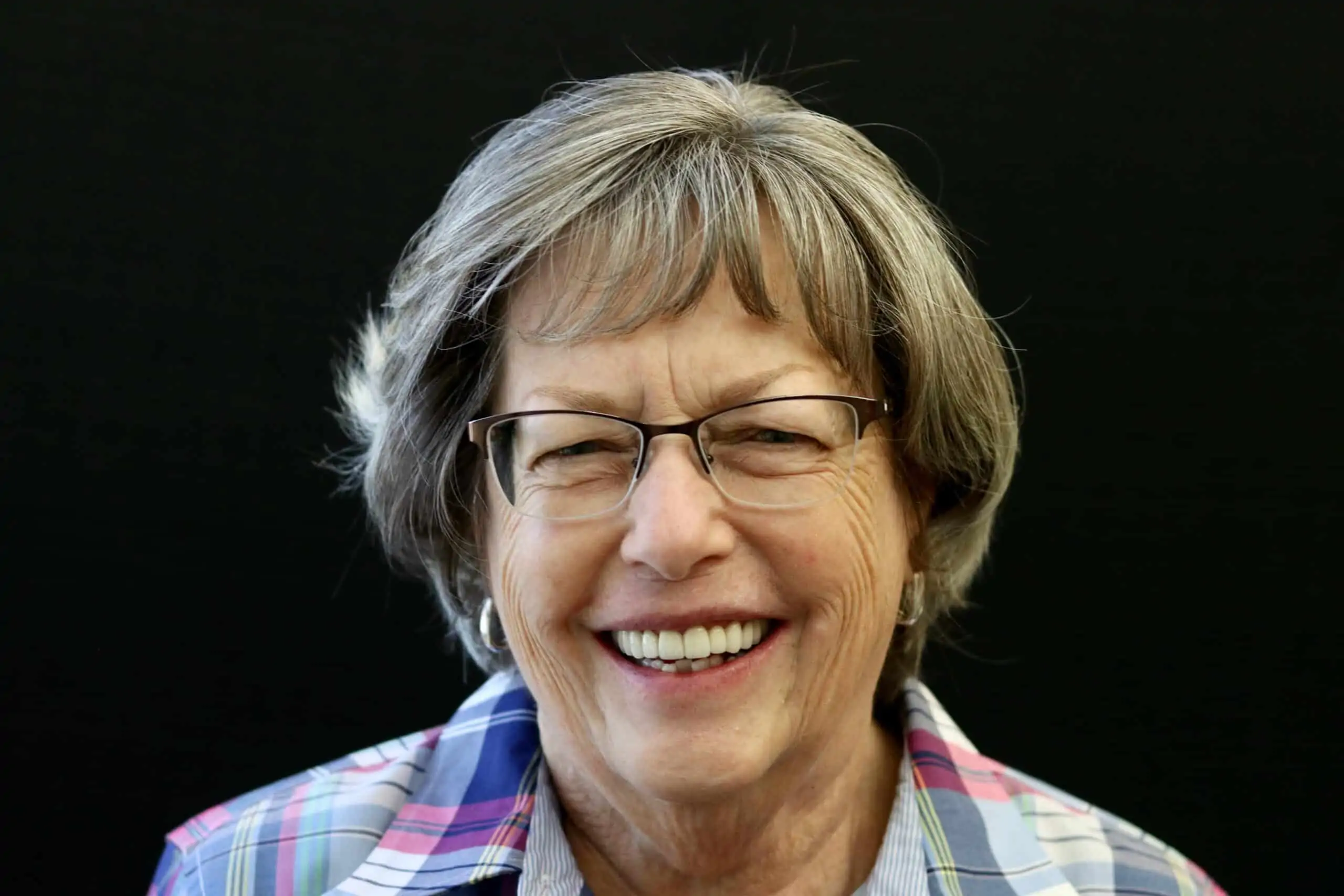 A patient smiling after receiving porcelain crowns at Signature Dentistry of Arvada 