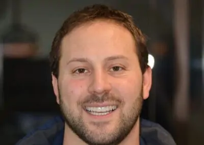 Patient smiling with straight, even, white teeth after receiving treatment at Signature Dentistry of Arvada